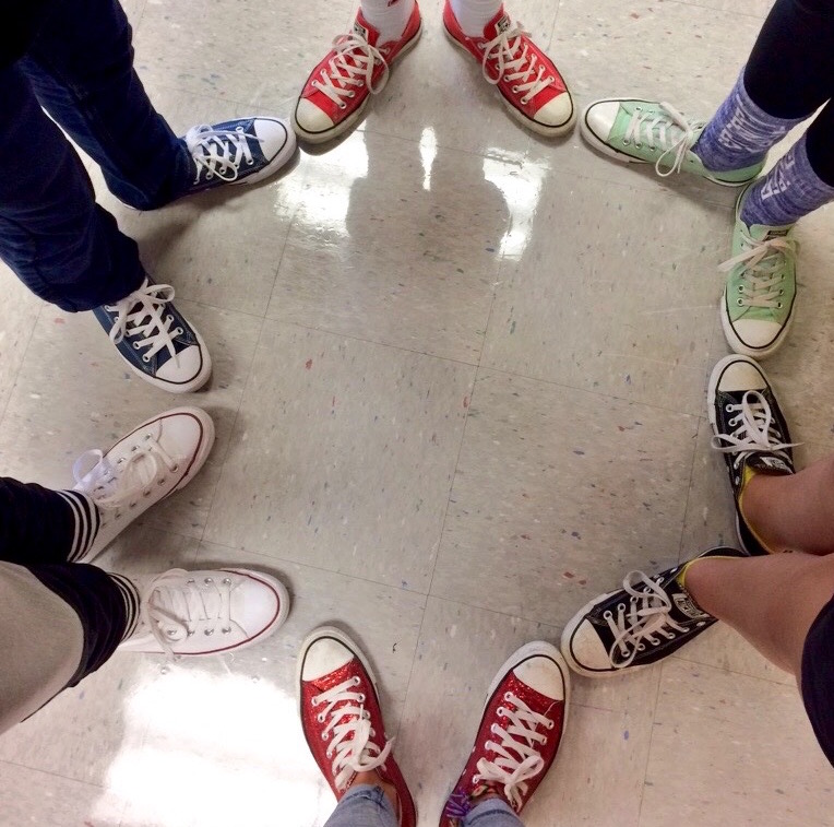 circle of people all wearing same shoes