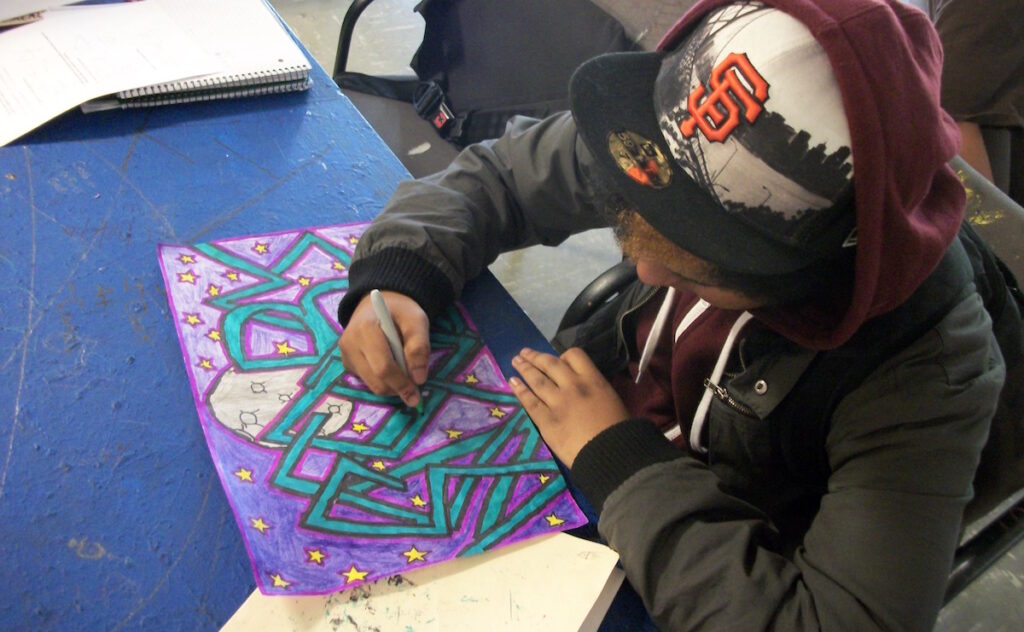 student working on graffiti piece