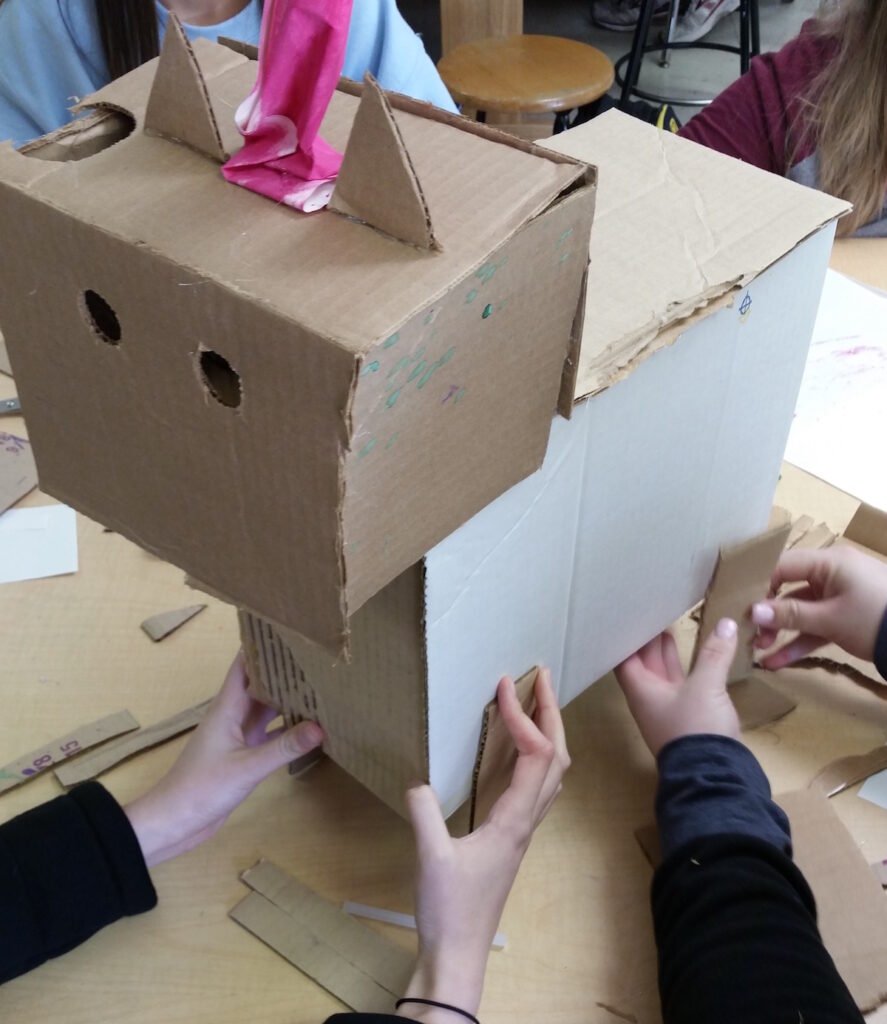 students collaborating on cardboard sculpture