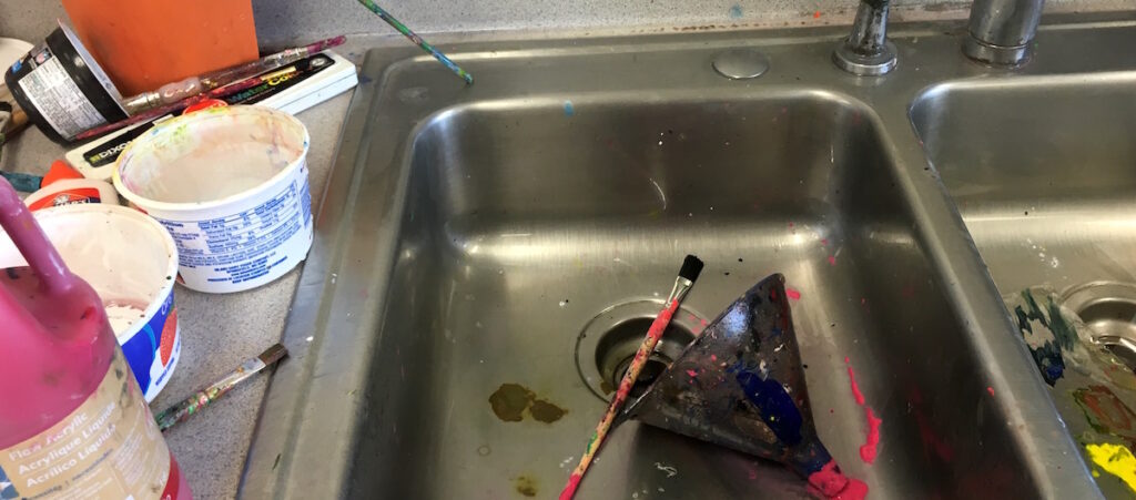 dirty paintbrush in sink