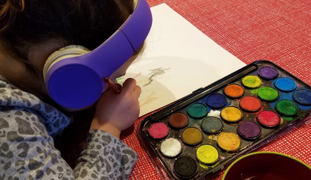 student painting while listening 