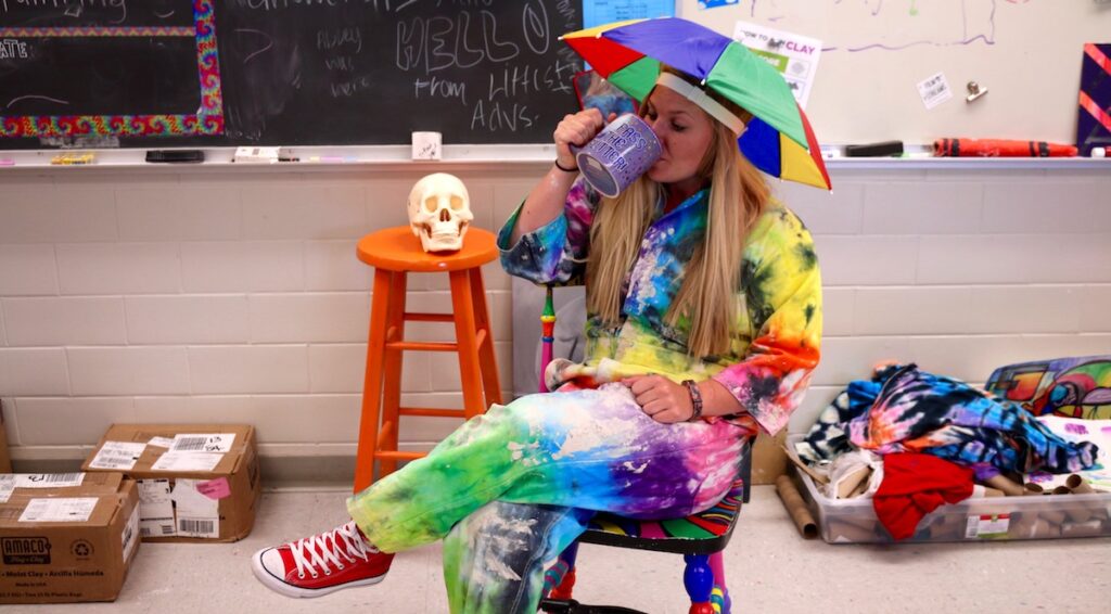 author dressed in tie-dye coveralls with umbrella on head