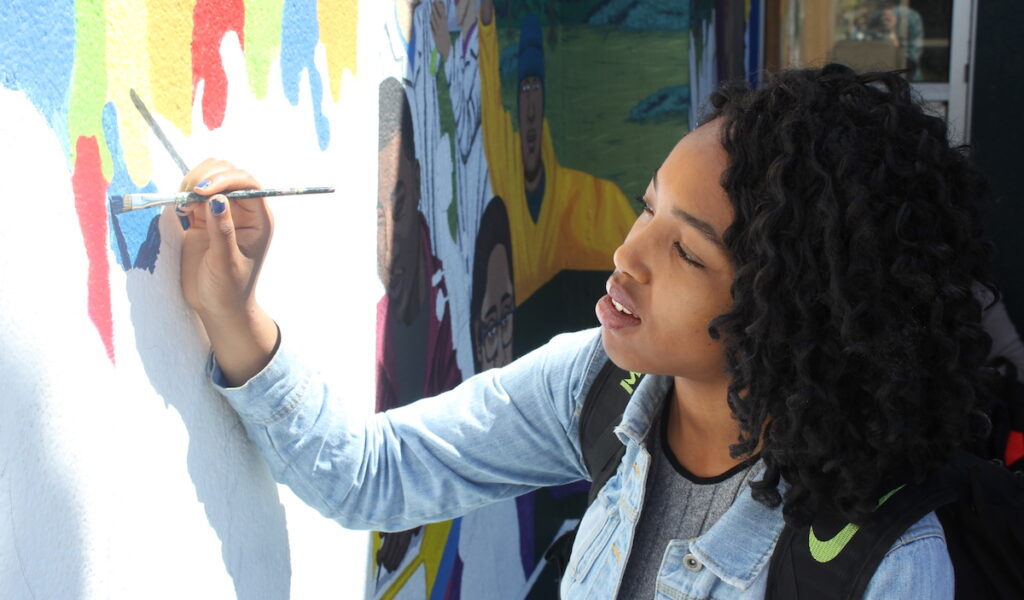 student working on mural