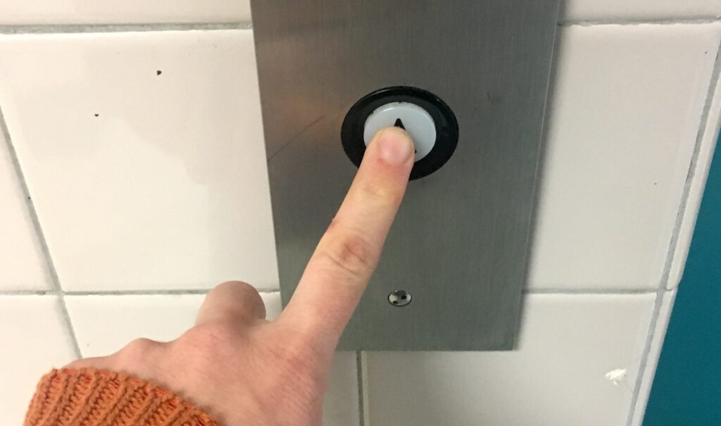 person pushing elevator button
