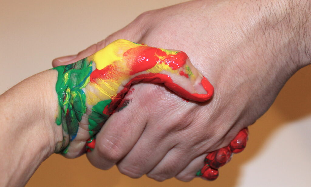handshake where one hand is painted