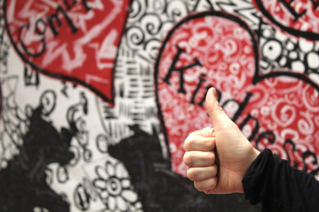 thumbs up in front of bulletin board