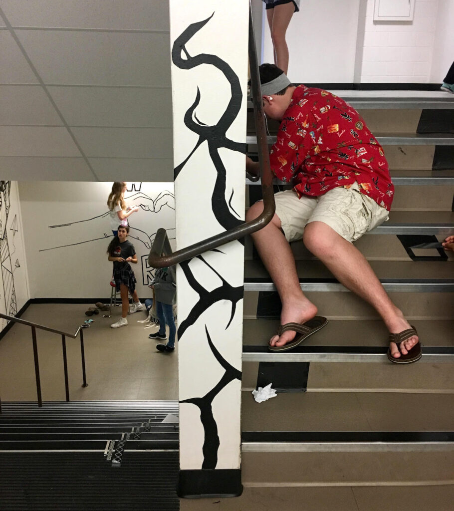 students working on tape mural in hallway