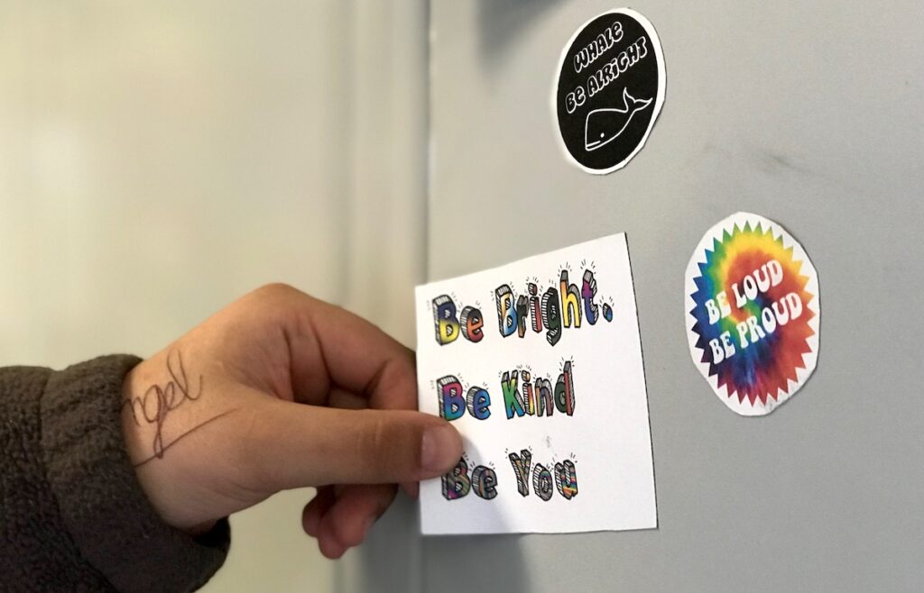 student holding sticker that says "Be Bright. Be Bold. Be You."