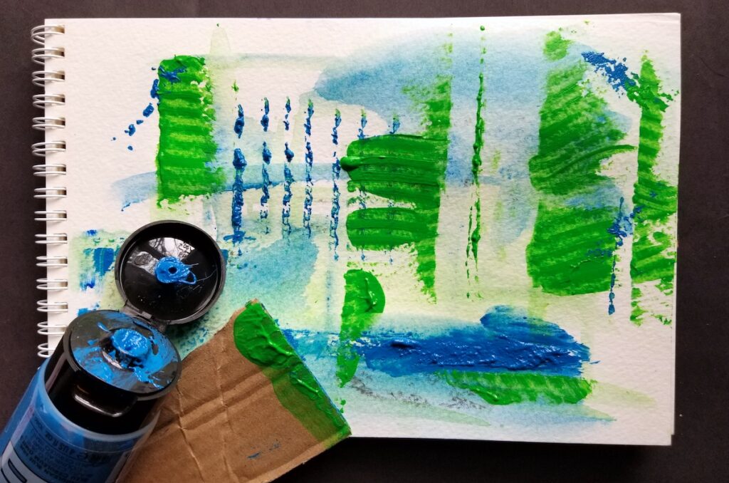 blue paint tube with painting and cardboard