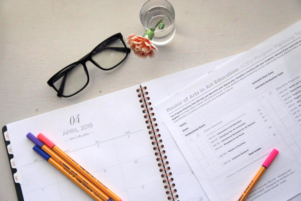 calendar, planning sheet, and glasses on desk