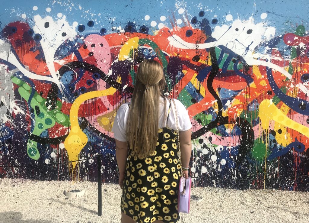 woman standing in front of mural