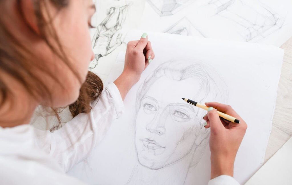 Artist drawing pencil portrait close-up