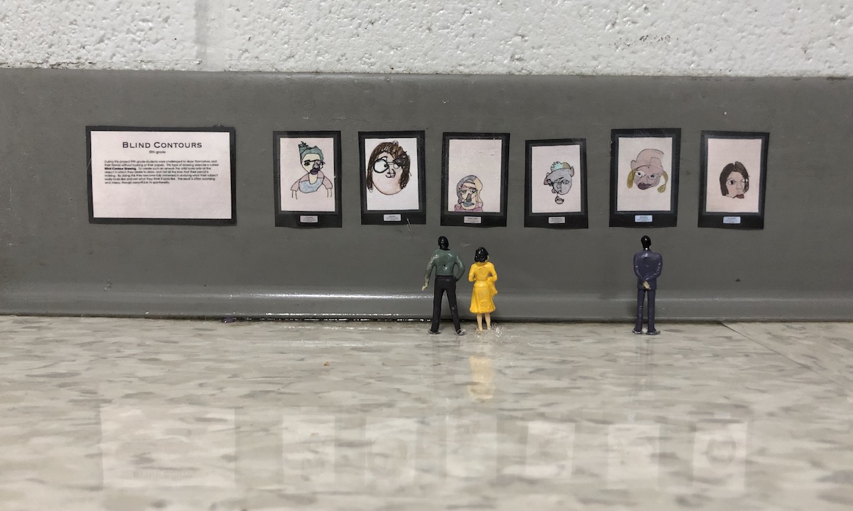 miniature figures looking at art