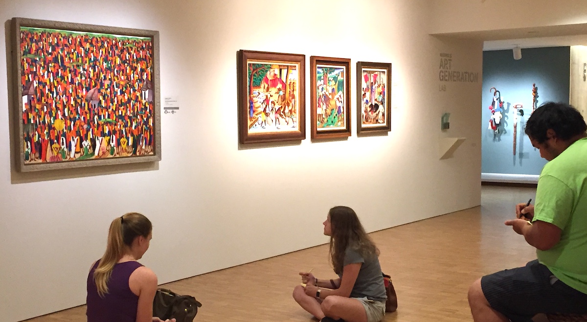students looking at colorful artwork in a musem