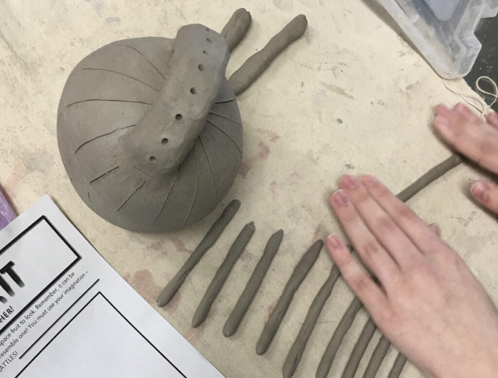 hands rolling out coils of clay