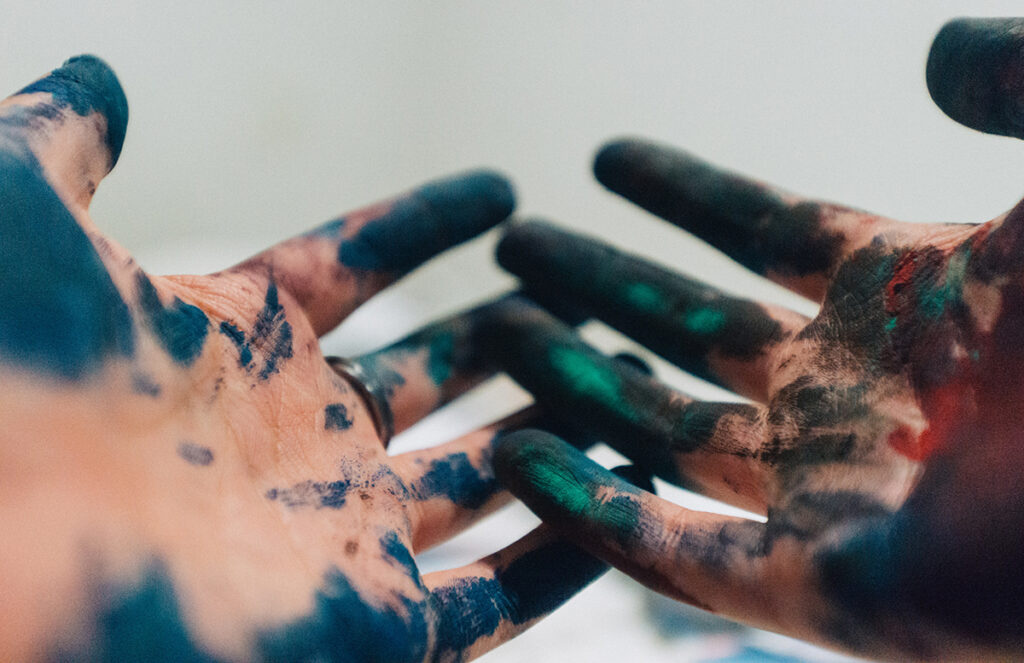 two hands with blue paint