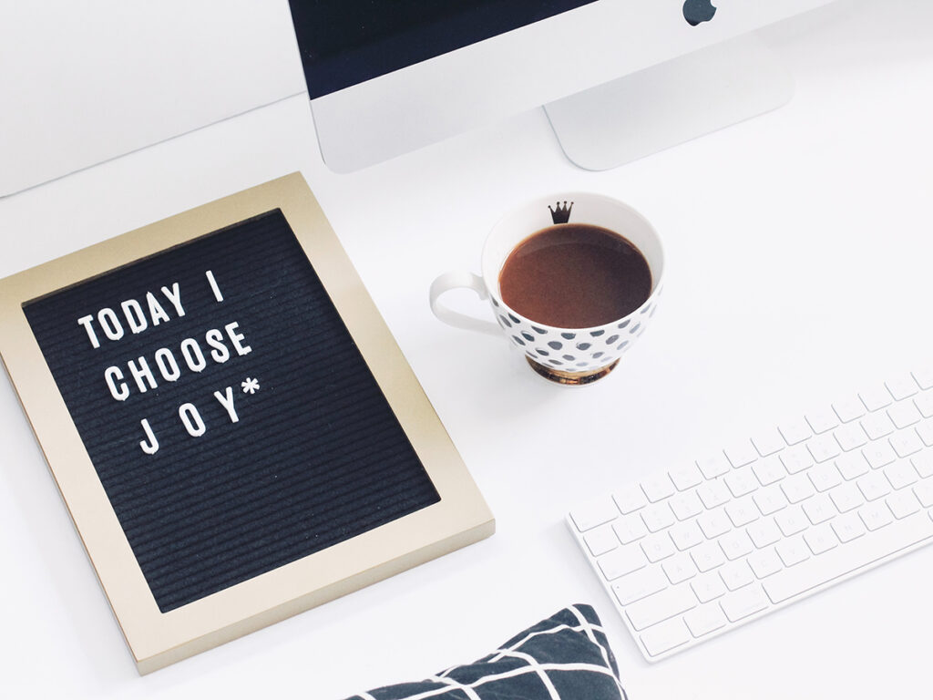 letterboard that says today I choose joy with a coffee cup and mac computer