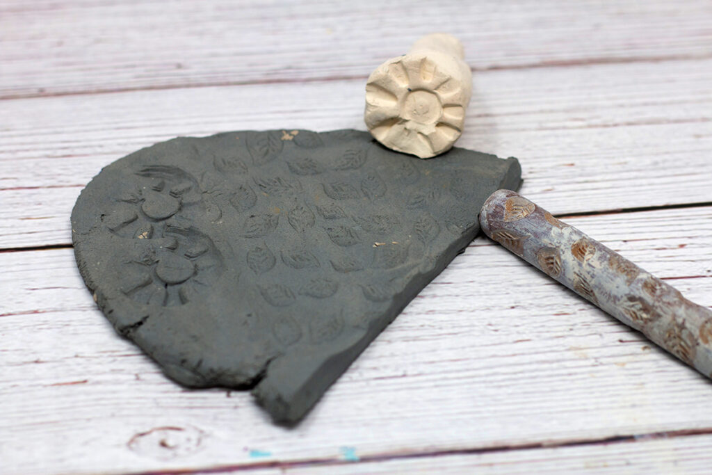slab of clay with a stamp and texture roller