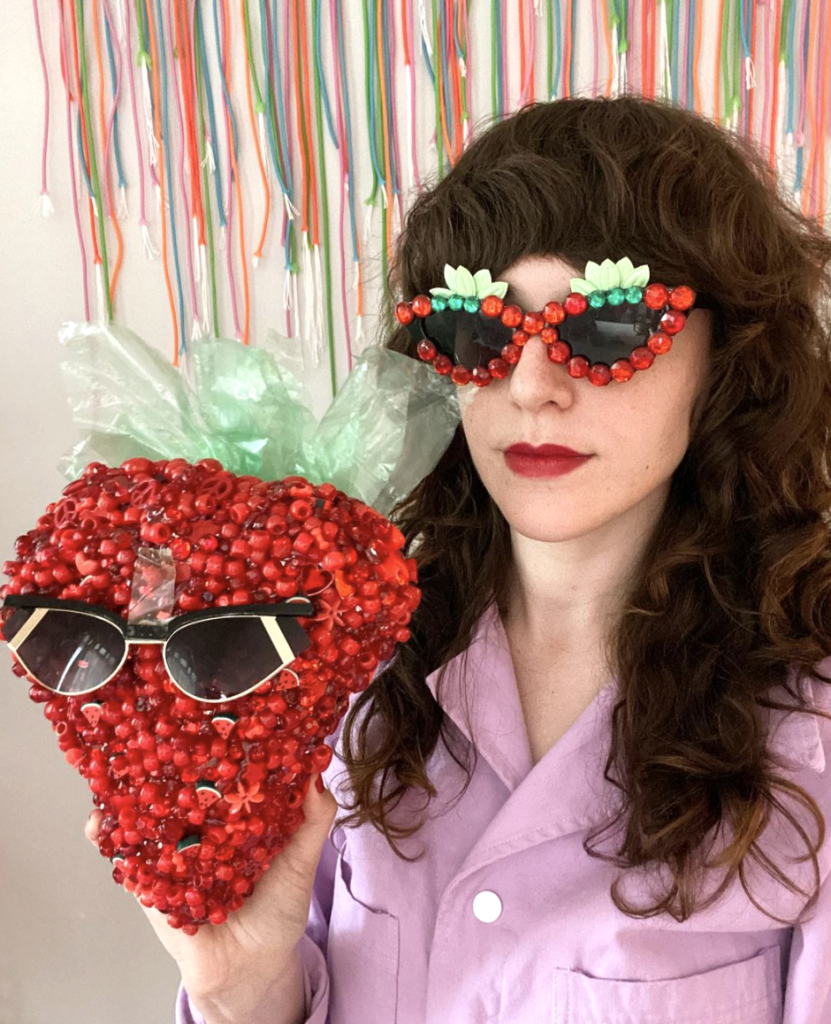 woman holding strawberry made of beads