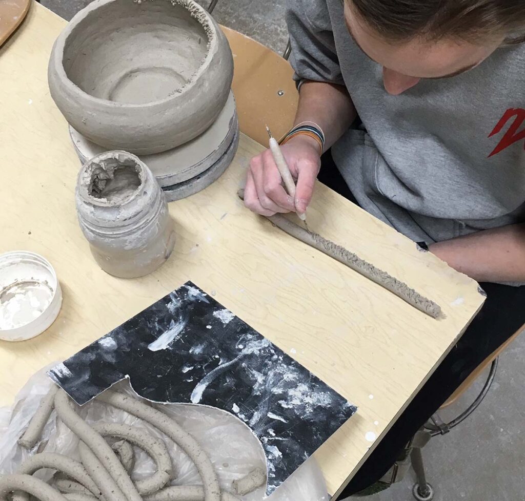 student scoring clay coil