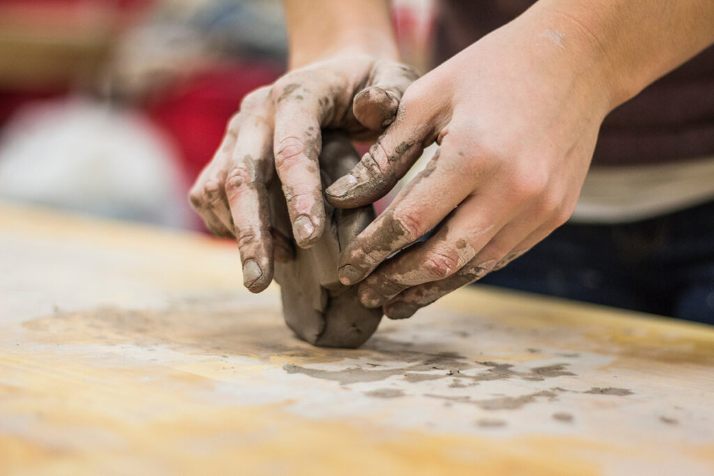 hands kneading clay