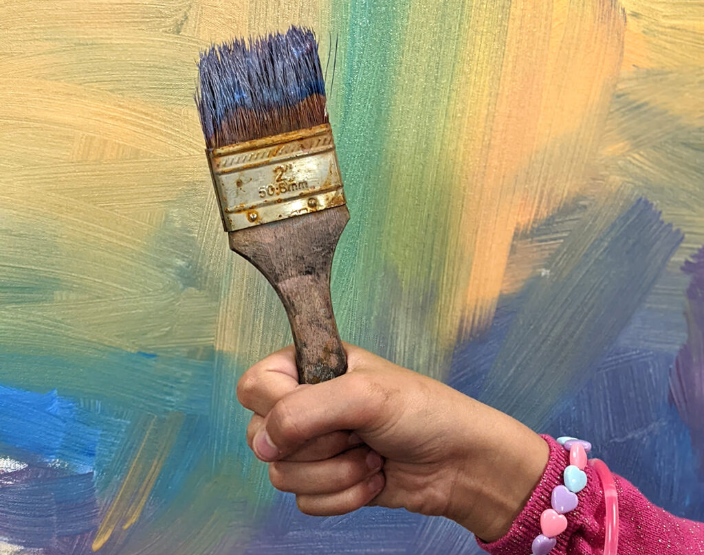 student holding paintbrush