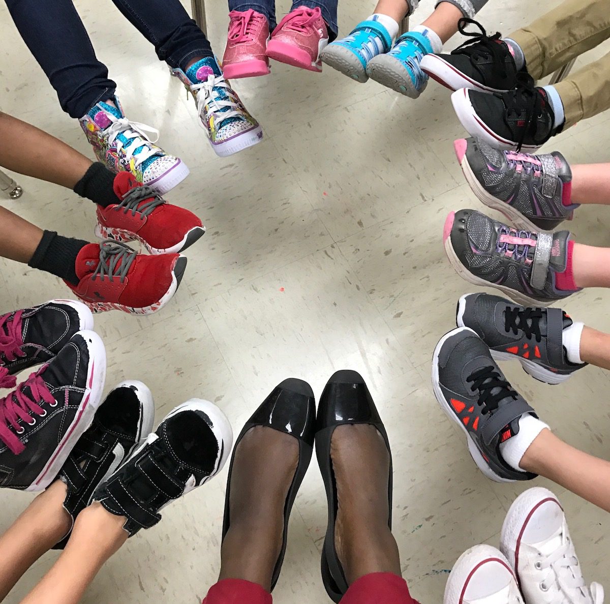 students' feet and teacher's feet in a circle