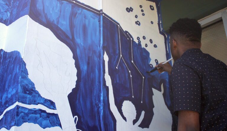 student working on mural
