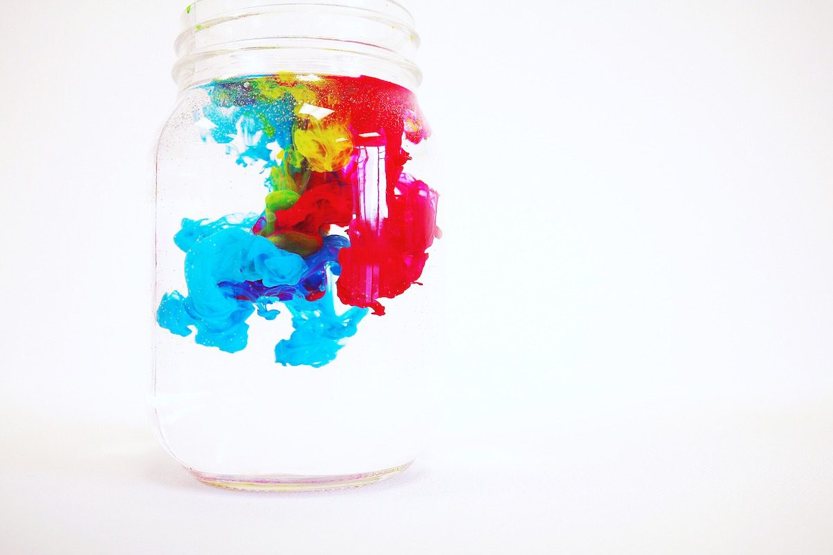 colors mixing in water in a jar