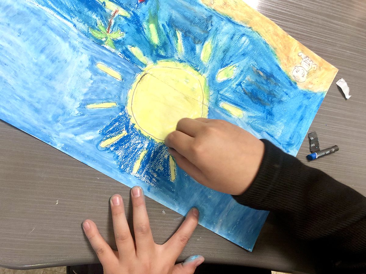 hands drawing a sun