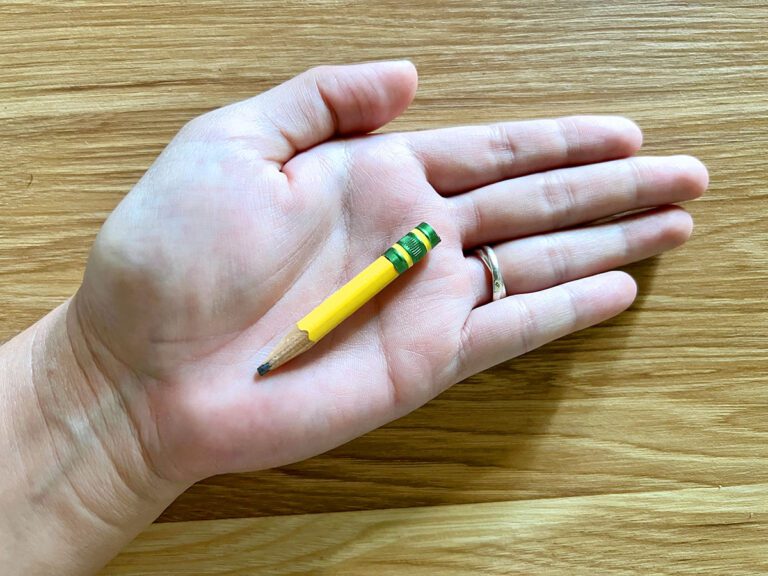 hand holding little pencil