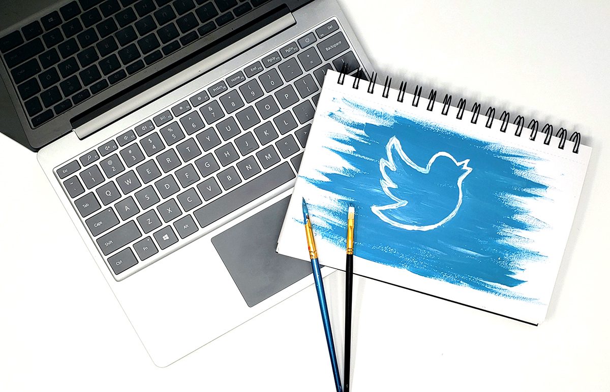 laptop and sketchbook with twitter logo