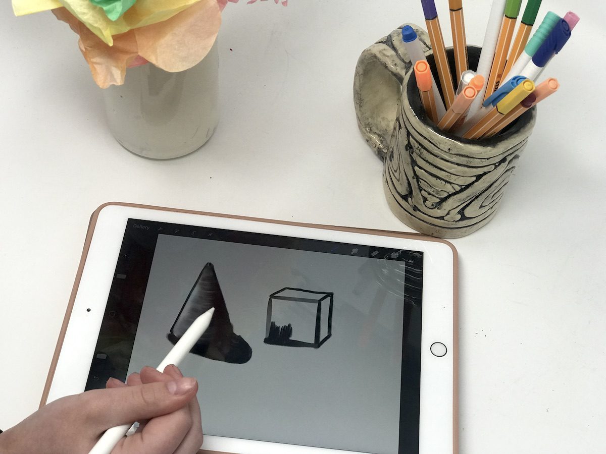 image of artist drawing a cone and cube digitally on an ipad