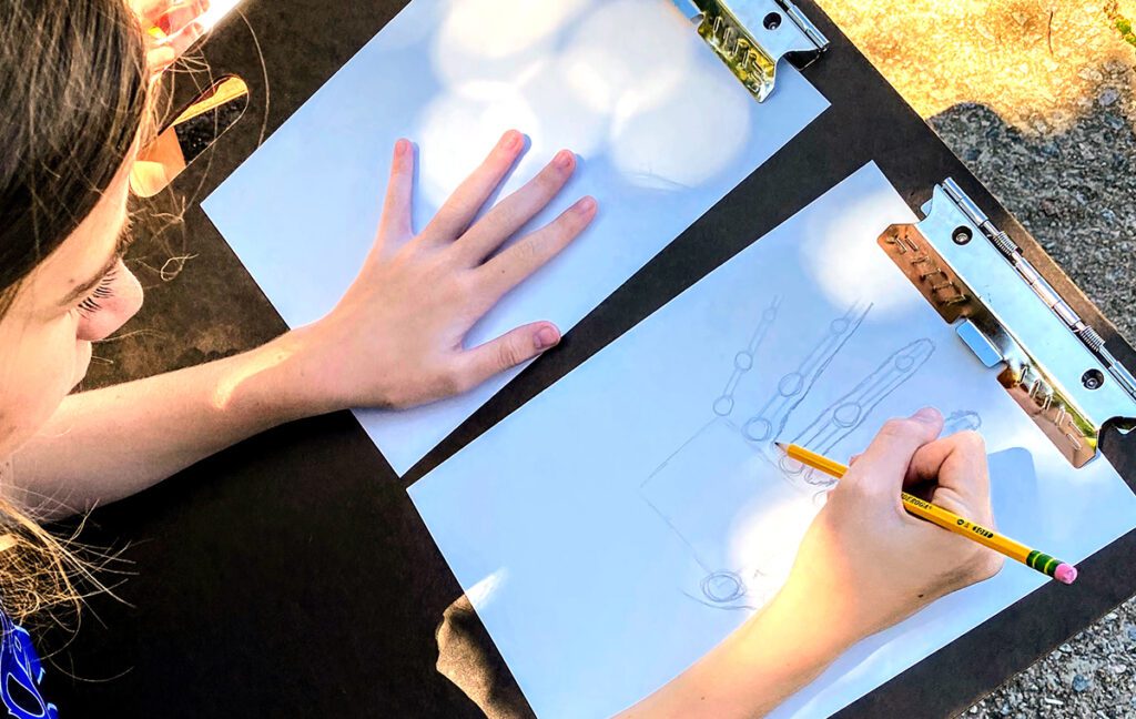 student drawing a hand