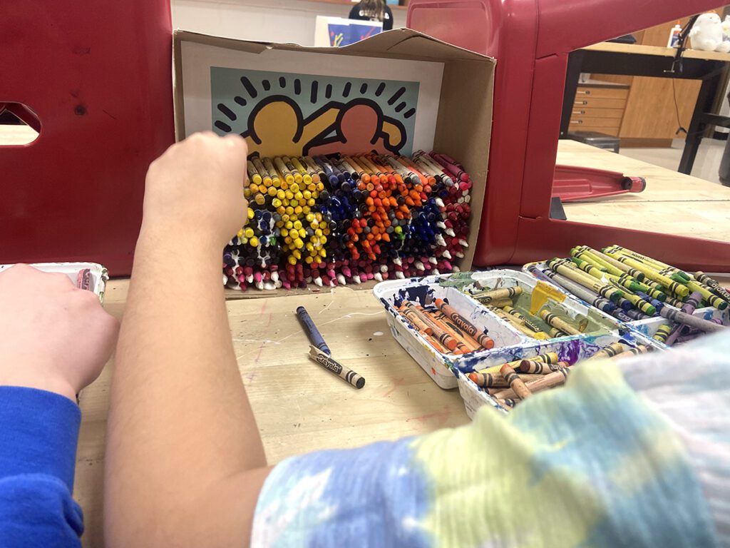 estudiante trabajando en el mosaico de crayones