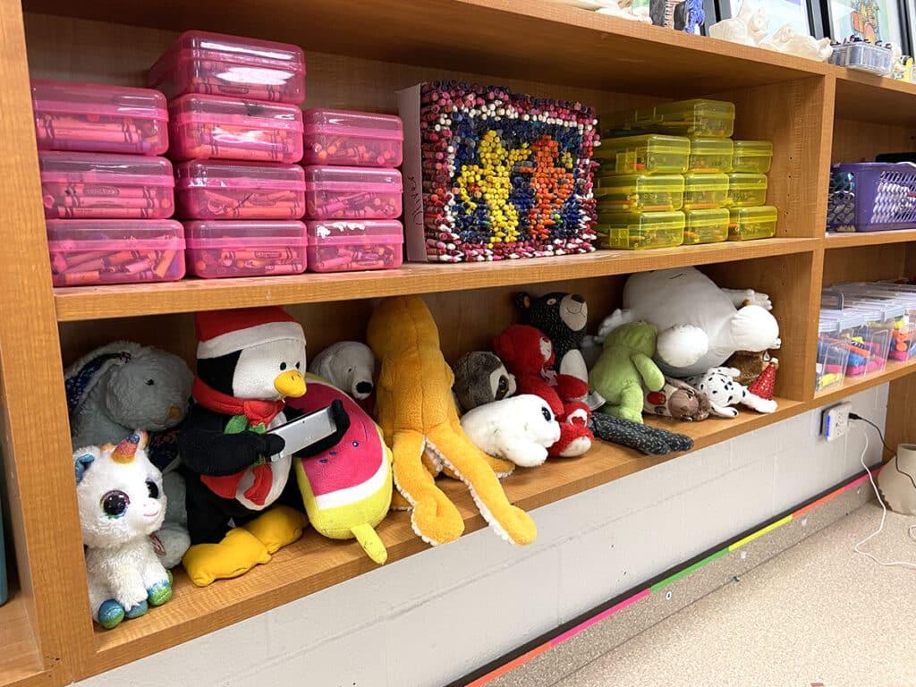 art supplies and stuffed animals on a shelf