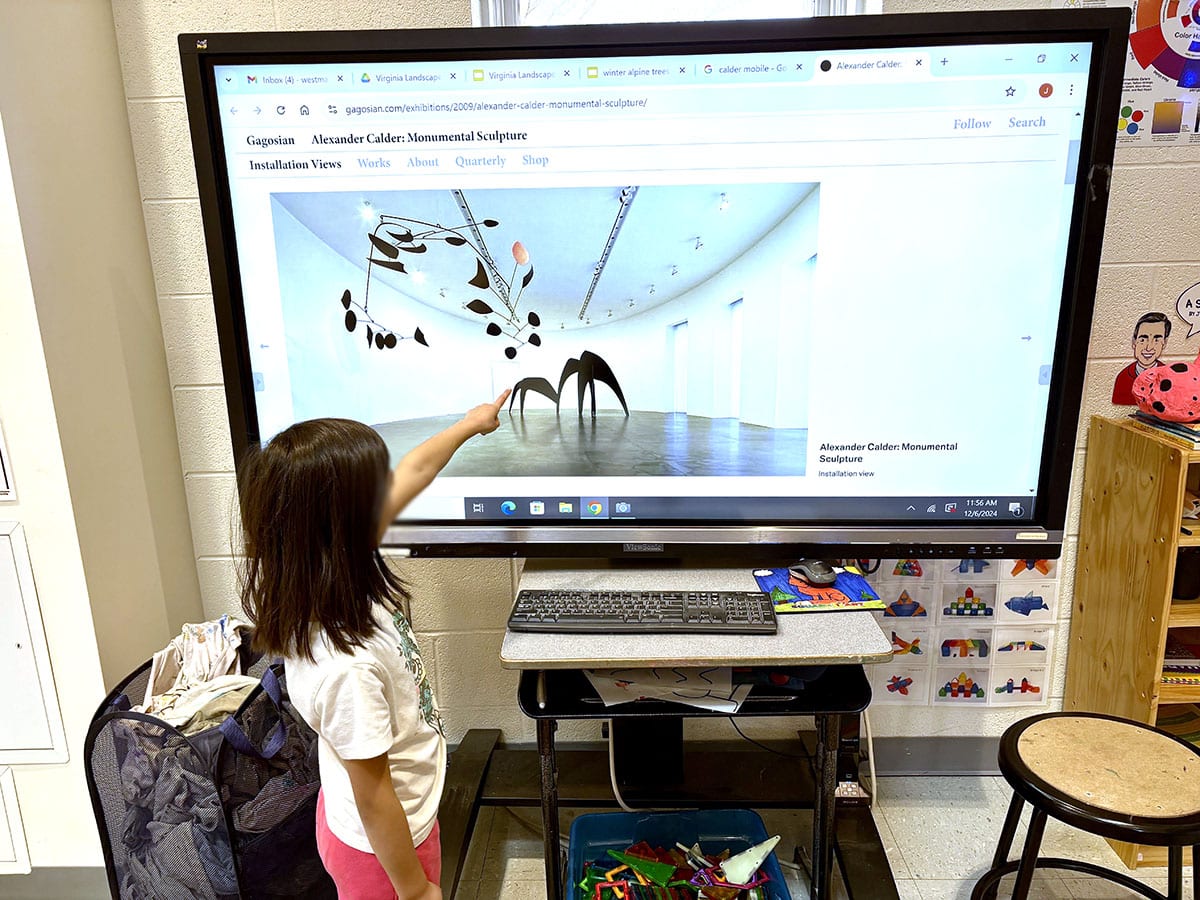 girl pointing at trivia on a smartboard