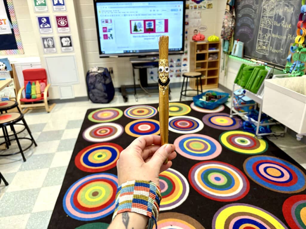 holding the golden paintbrush in an art room