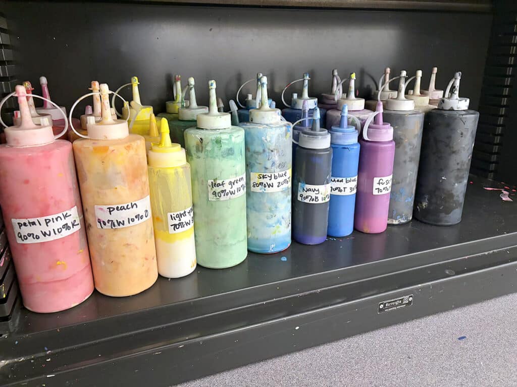 shelf of paint in rainbow order