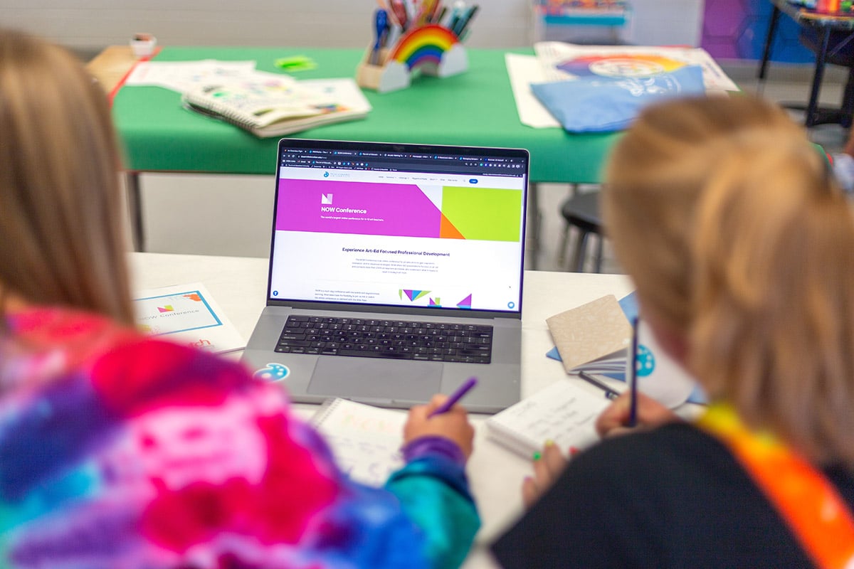 two art teachers with a laptop with the NOW landing page
