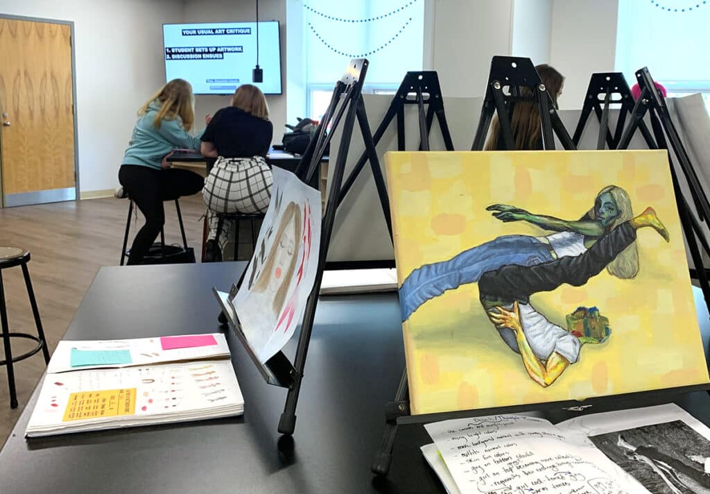 student artwork on easels with sketchbooks