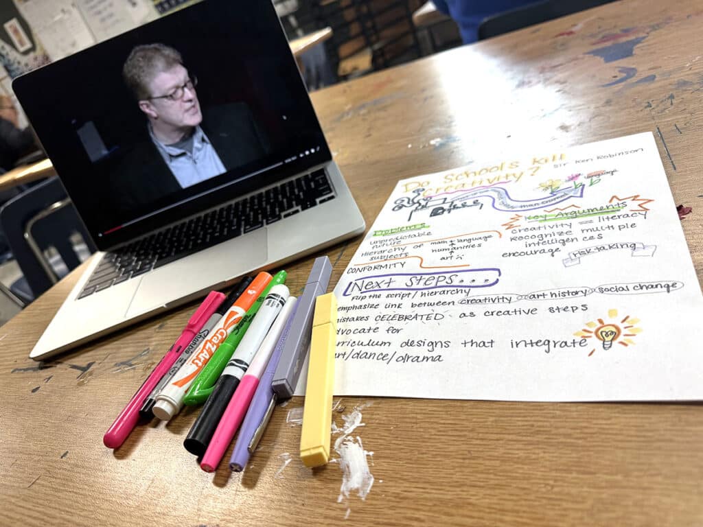 TED Talk on a laptop with sketchnotes page and markers