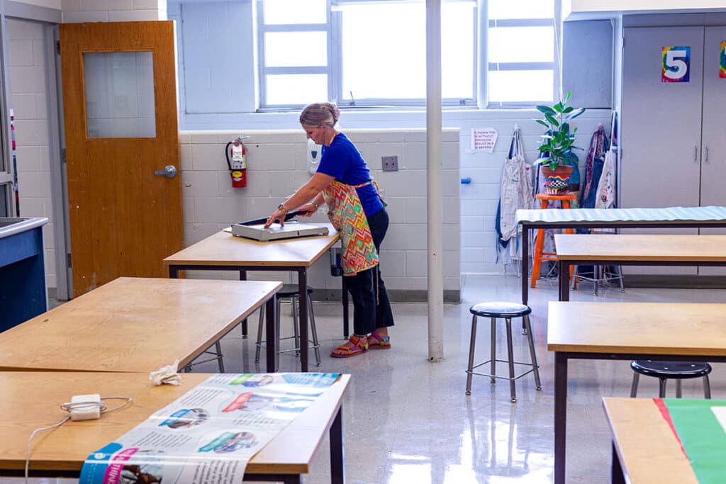 teacher cutting paper in the art room