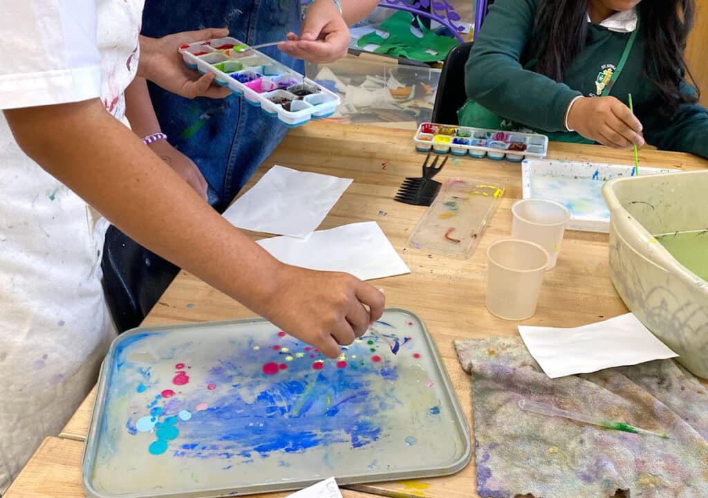 students working together to mix paint