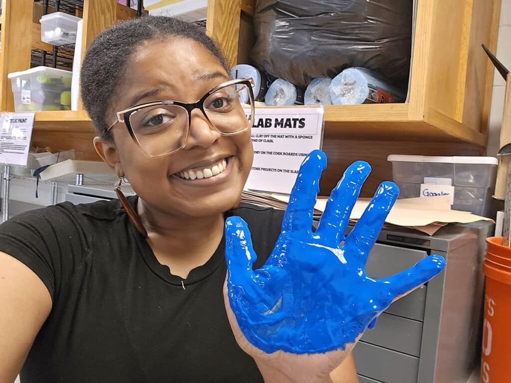 liz brent with a blue painted handprint