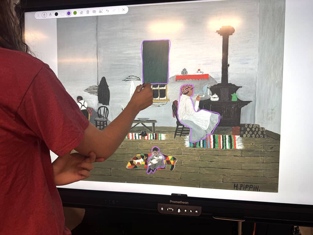 student annotating an artwork on a smartboard