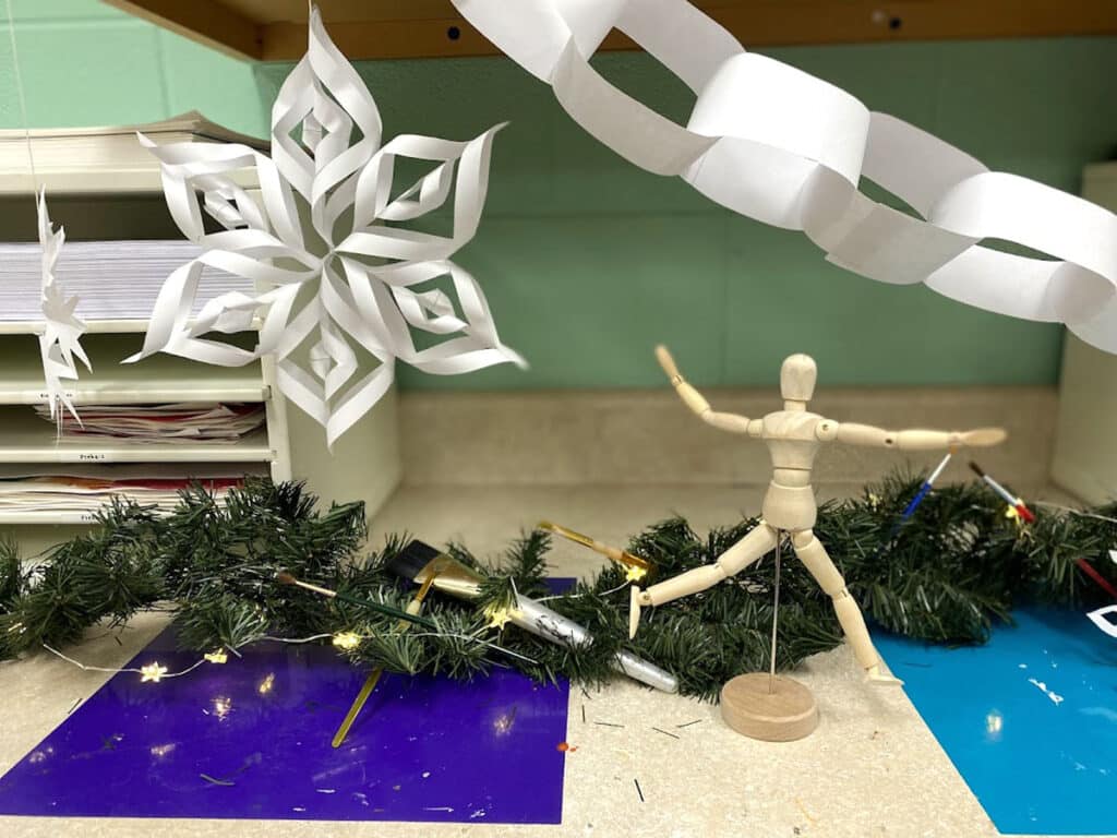 wooden mannequin with paper snowflakes and chain