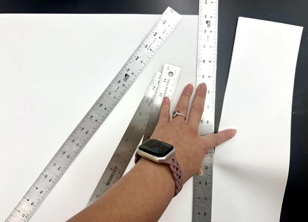 hand tearing paper with a stainless steel ruler