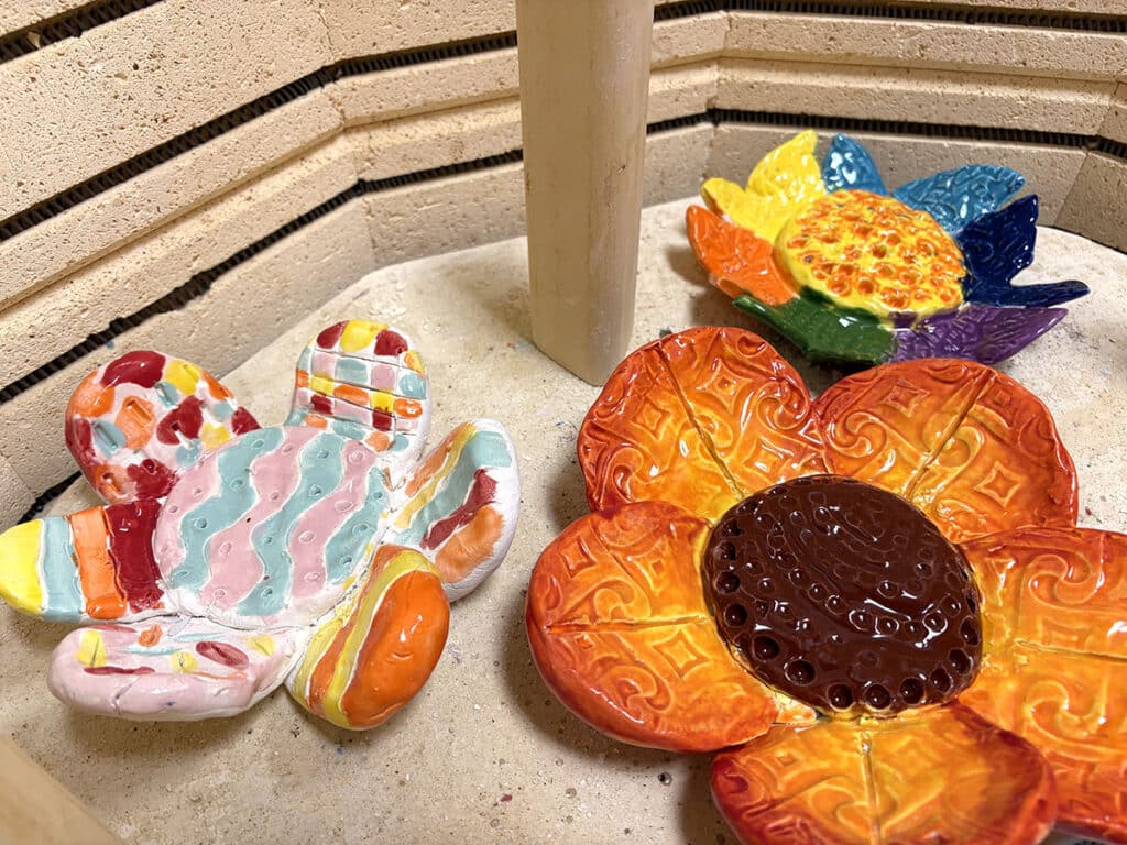 three glazed flower bowls in a kiln