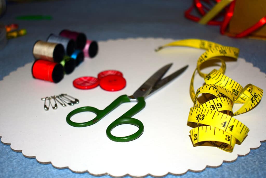sewing supplies with thread, tape, and scissor